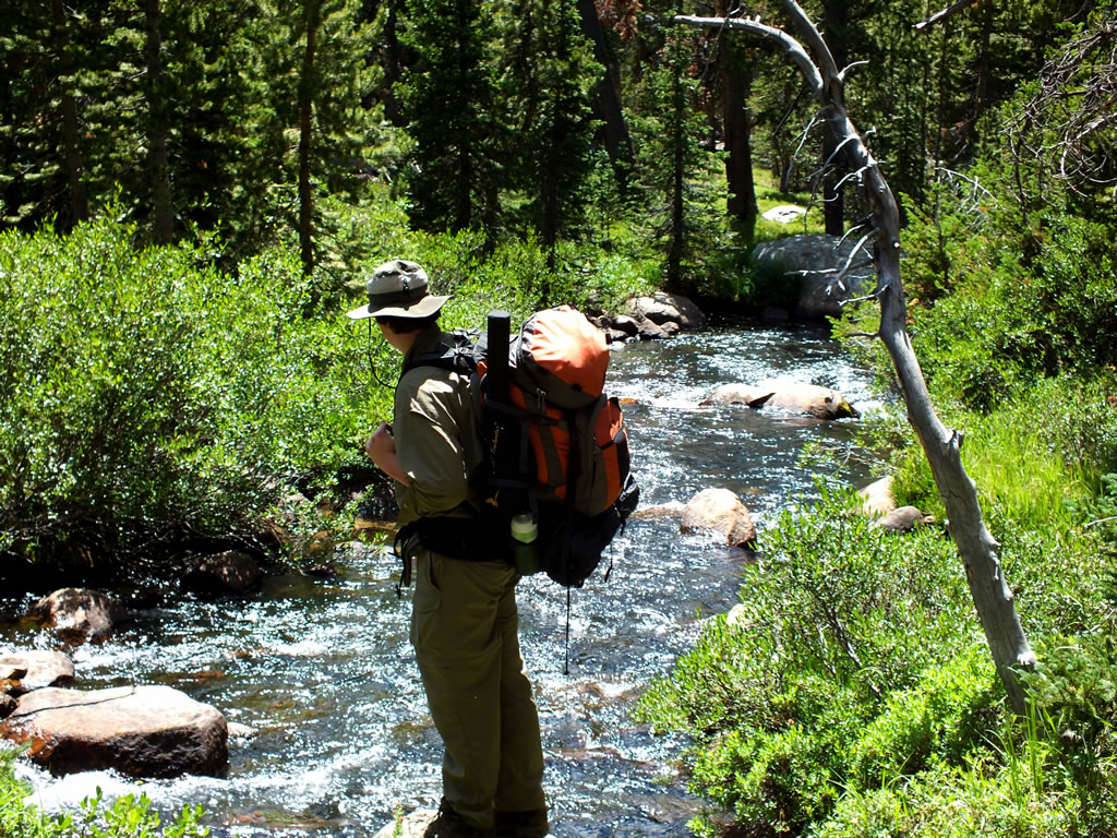 Dallen wearing a Alps Red Tail pack looking at a stream coming out of the Stough Creek Basin